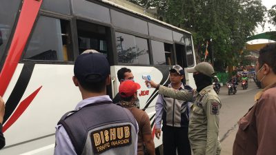 Pemeriksaan suhu tubuh di depan gerbang terminal induk bekasi bagi pendatang pengguna transportasi umum