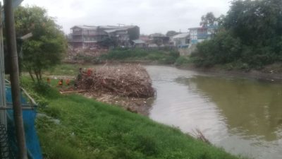 Gumpalan sampah bambu, kayu dan ranting pohon yang nampak di Kali Bekasi, Jalan M.Hasibuan, Kota Bekasi. Foto: Gobekasi.id