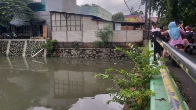 Warga memantai debit air Kali Jati pasca hujan lebat di wilayah Kayuringi, Kota Bekasi, Senin (8/2/2021). Foto: Gobekasi.id