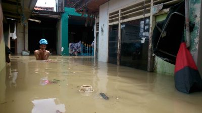 Warga menerobos banjir 1,5 meter di Kampung Lebak, Kelurahan Teluk Pucung, Bekasi Utara yang rata dengan Kali Bekasi, Senin (8/2/2021). Foto: Gobekasi.id