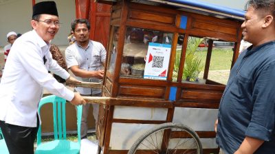 Pj Bupati Bekasi Dani Ramdan mendorong gerobak mie bakso. Foto: Ist