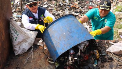 Pj Bupati Bekasi Dani Ramdan ikut membantu membuang sampah yang berserakan ke kontainer sampah. Foto: Ist
