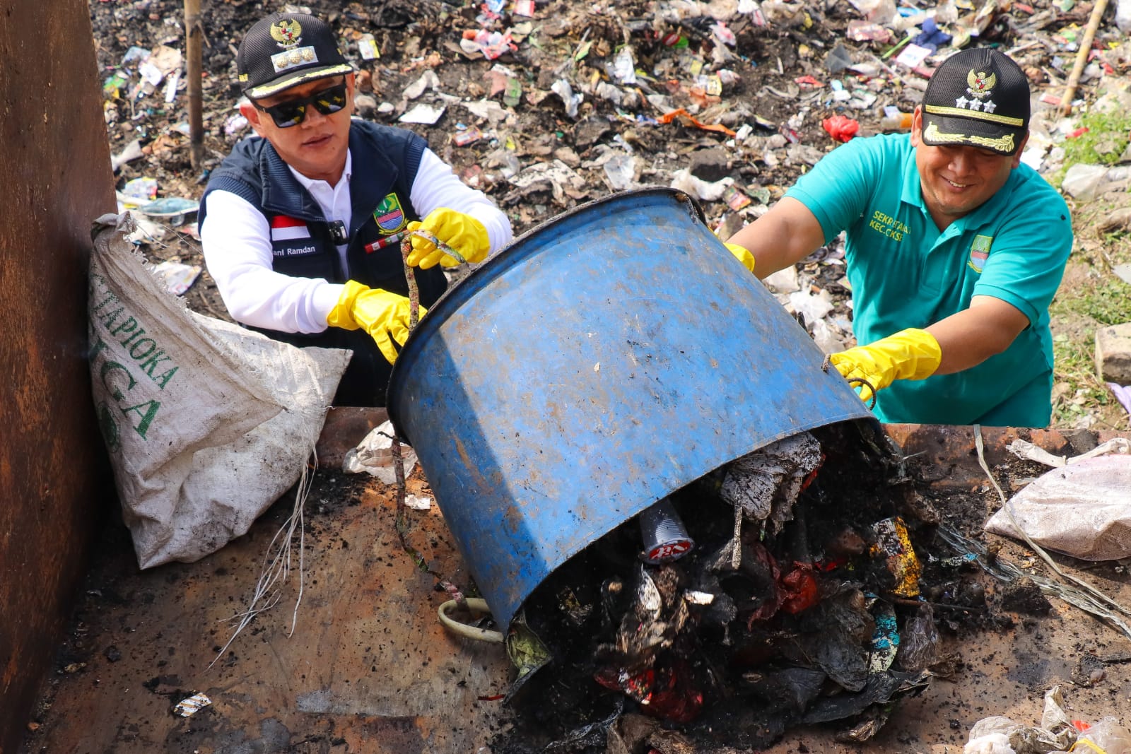 Pj Bupati Bekasi Dani Ramdan ikut membantu membuang sampah yang berserakan ke kontainer sampah. Foto: Ist