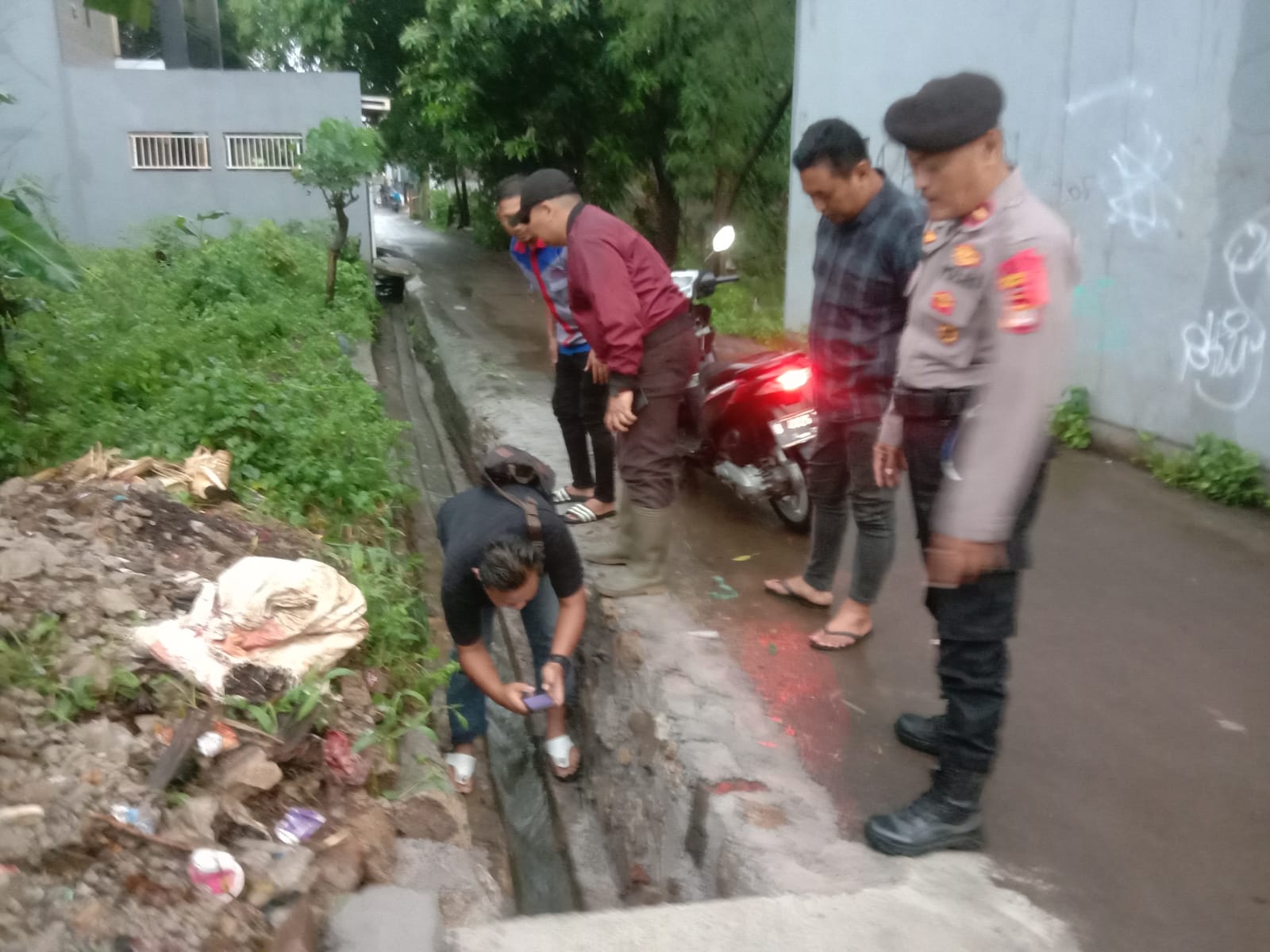 Saluran air tempat menghilangnya IF (10). Bocah laki-laki itu dinyatakan hilang dan meninggal dunia ketika bermain bersama tiga temannya saat hujan deras mengguyur wilayah Pangkalan Asem Bantargebang, Kota Bekasi, Kamis (4/1/2023) sore. (Dok.Polres Metro Bekasi Kota).