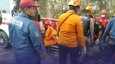 Petugas BPBD Kota Bekasi mengevakuasi satu jenazah korban kebakaran di pabrik Bekasi. Foto: Ist