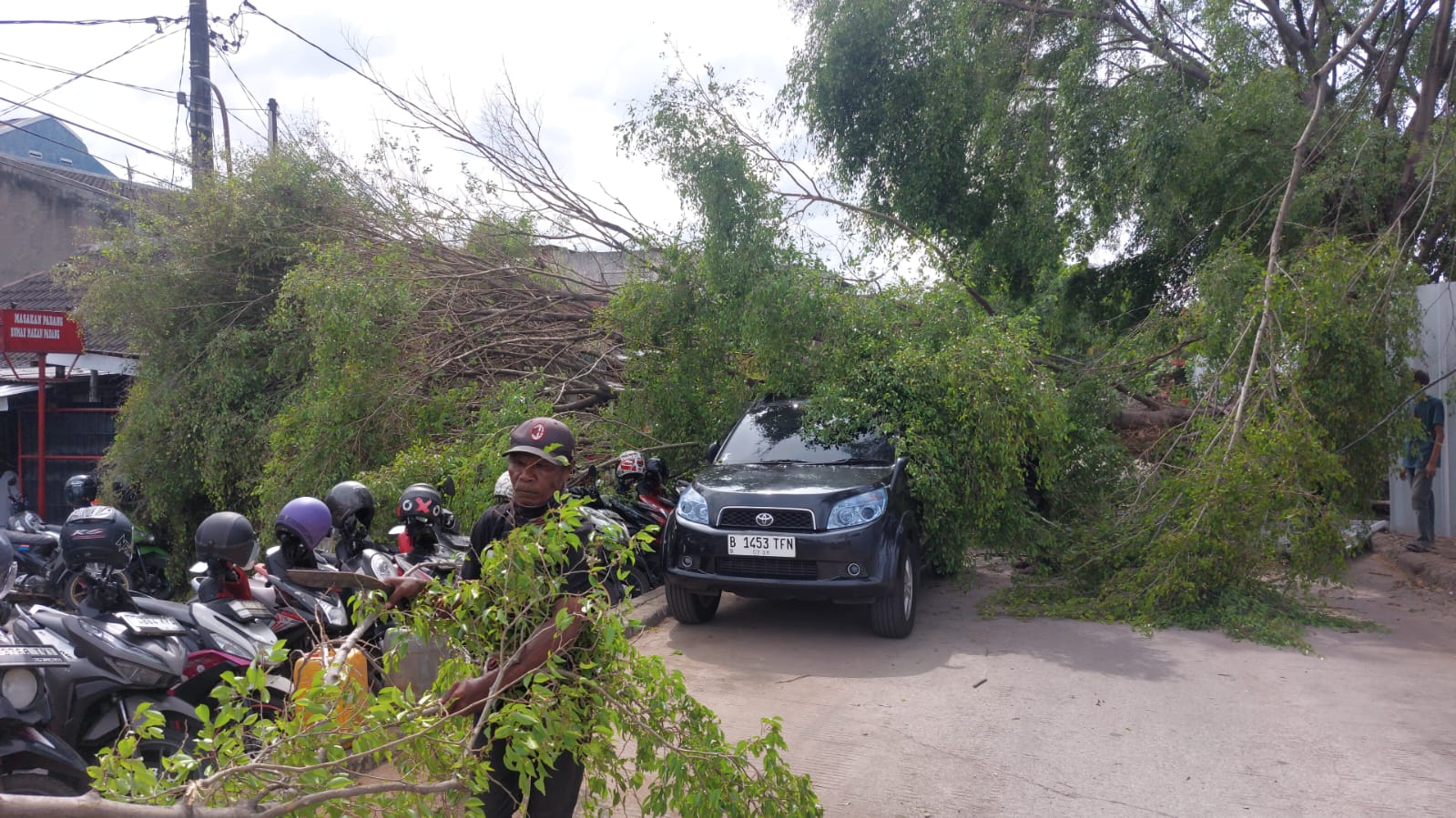 Pohon tumbang di samping RS Mitra Keluarga Bekasi Barat timpa kendaraan. Foto: Ist