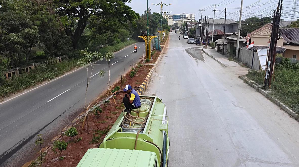 Pekerja Menyiram taman median Jalan Kalimalang