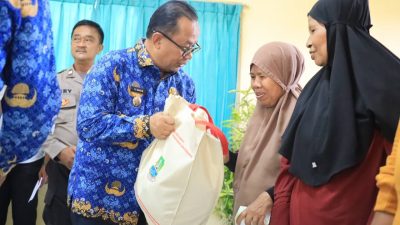 Pj Wali Kota Bekasi Raden Gani Muhamad secara simbolis memberikan bantuan pangan kepada warga di rawalumbu. Foto: Ist