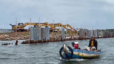 Seorang nelayan tengah melintas di sekitar pembangunan alur pelabuhan di perairan Kampung Paljaya, Desa Segara Jaya, Tarumajaya, Kabupaten Bekasi.(ACHMAD NASRUDIN YAHYA/KOMPAS.com)