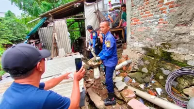 Disdamkar Kanupaten Bekasi mengevakuasi ular sanca yang masuk kandang hewan ternak warga