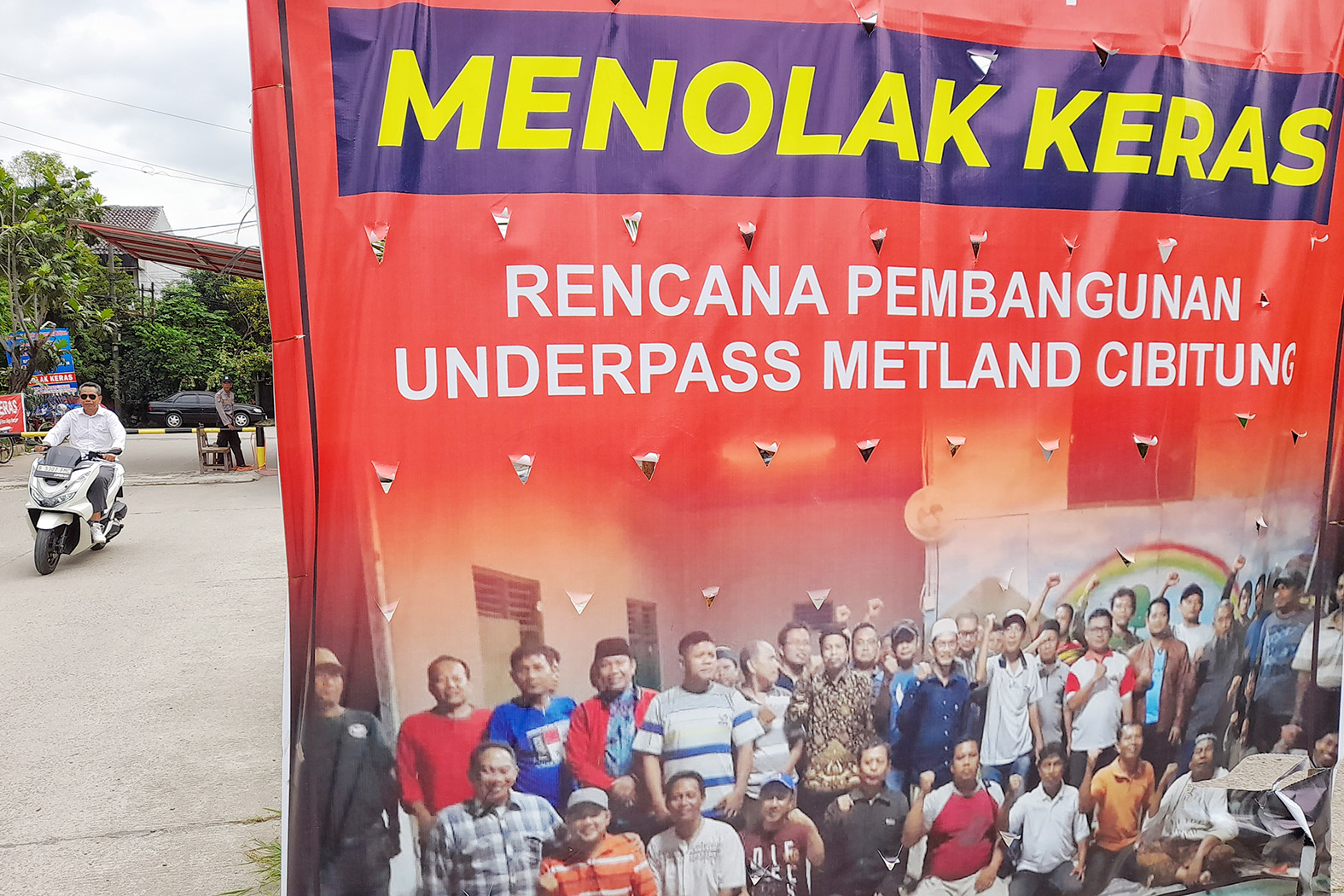 Warga melintasi spanduk penolakan rencana pembangunan underpass Metland Cibitung di Perumahan Telaga Harapan Desa Telagamurni Kecamatan Cikarang Barat Kabupaten Bekasi, Senin (17/2). ARIESANT/RADAR BEKASI