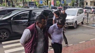 Pelaku pemerasan yang mengaku-ngaku sebagai wartawan saat tiba di Mapolda Metro Jaya, Jakarta Selatan, Rabu (12/2/2025). Komplotan wartawan gadungan itu punya modus melakukan paparazi dan memeras tamu hotel.