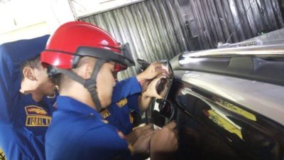 Disdamkarmat Kota Bekasi saat berupaya membuka pintu mobil yang terkunci. Foto: Ist