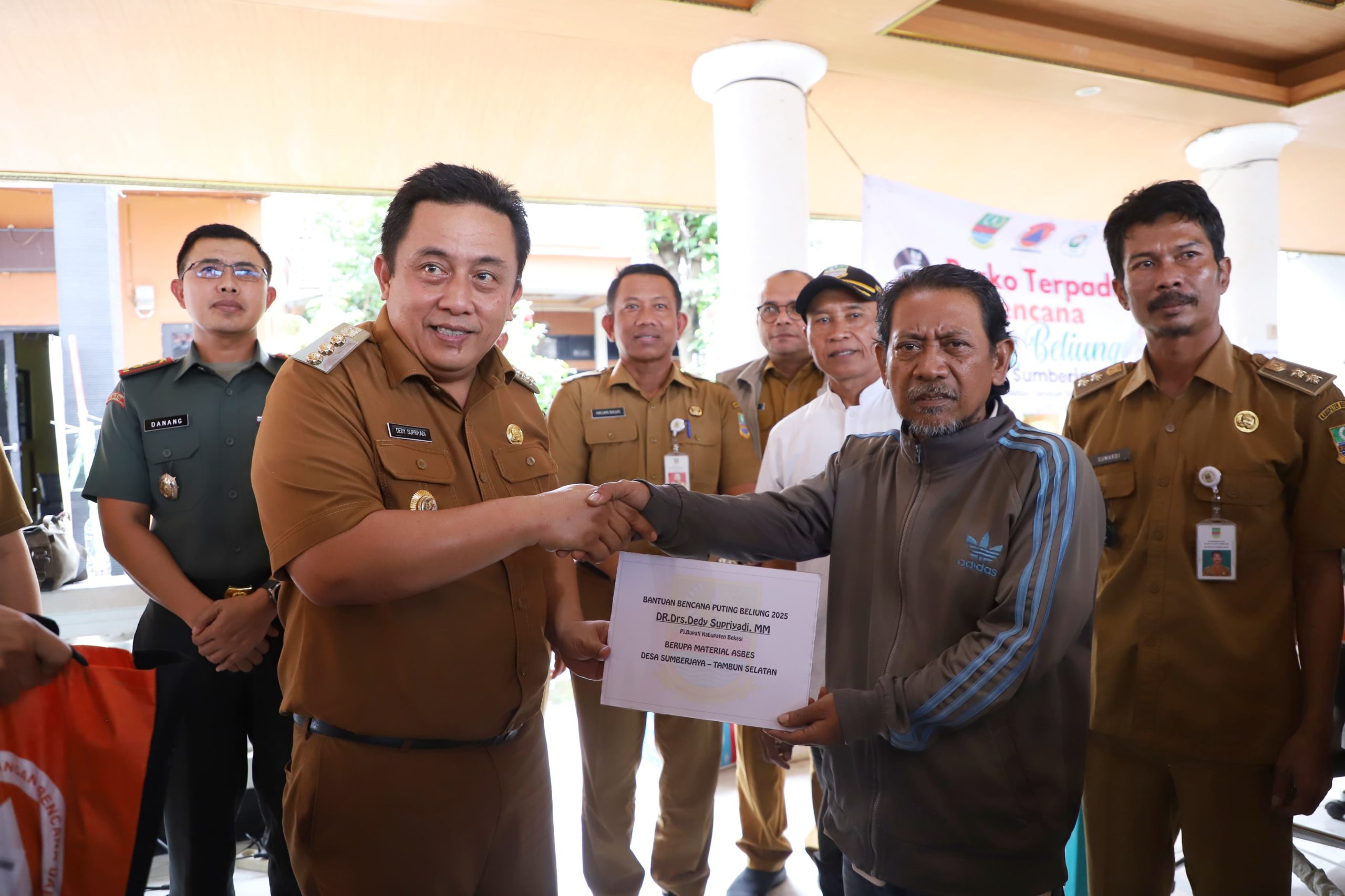 Pj. Bupati Bekasi Dedy Supriyadi bersama Dandim 0509/Kabupaten Bekasi Letkol Inf. Danang Waluyo, menyalurkan bantuan sekaligus meninjau rumah warga yang terdampak bencana Hidrometeologi angin puting beliung, di Kp. Buek, RW 28, Desa Sumber Jaya. Kecamatan Tambun Selatan. Pada Senin, (10/02/2025).