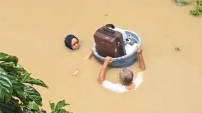 Pasangan Lansia menerjang banjir di Kompleks Keuangan, Jalan Guntur 7, Kayuringin Jaya, Bekasi Selatan, Kota Bekasi, Selasa (4/3/2025). Foto: Gobekasi.id