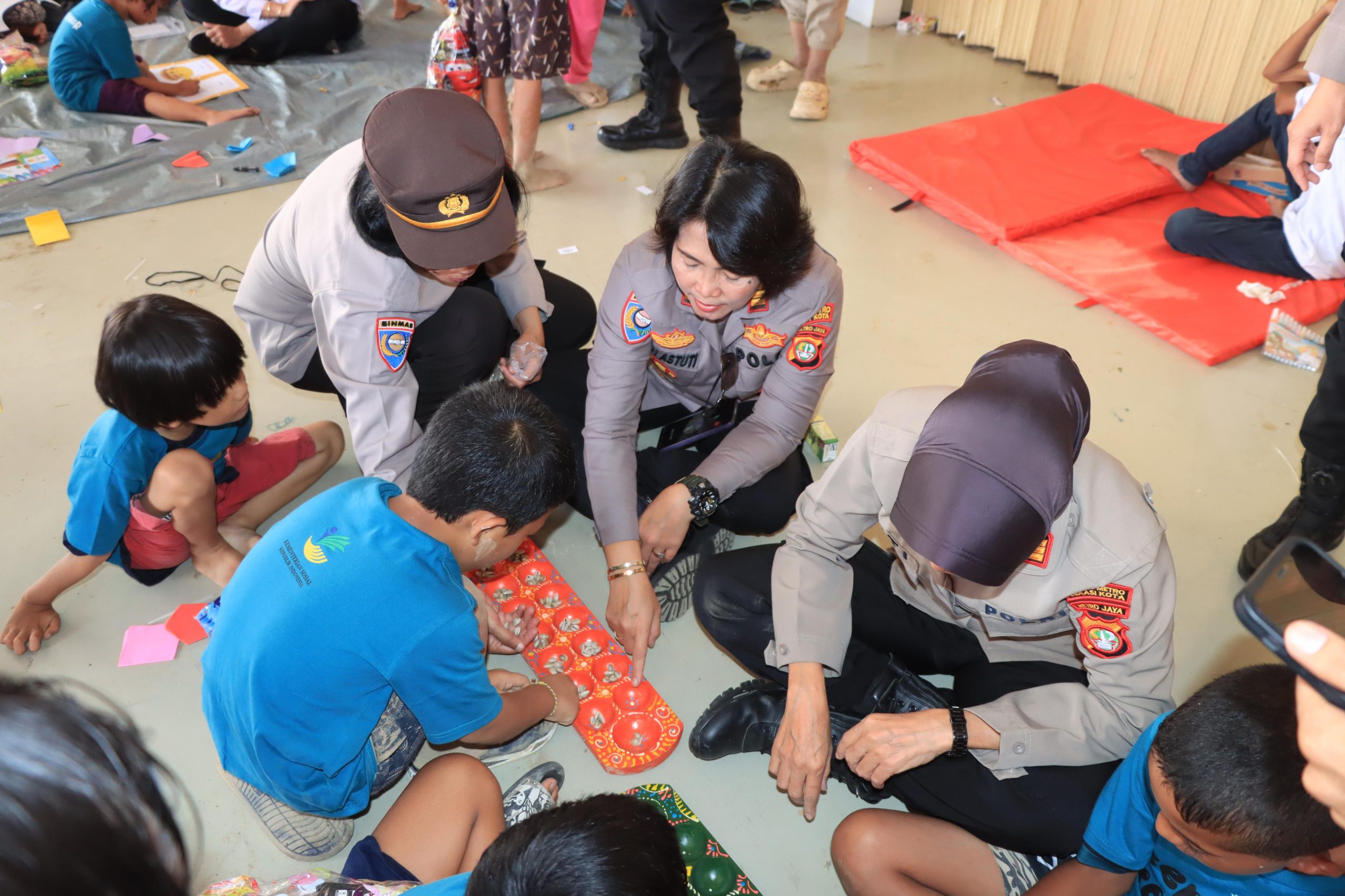 Polisi Wanita (Polwan) Polres Metro Bekasi Kota memberikan bantuan trauma healing kepada anak - anak korban banjir di Perumahan Pondok Gede Permai, Jatiasih, Kota Bekasi ditengah kunjungan Wakil Presiden Gibran Rakabuming Raka, Rabu (5/3/2025).