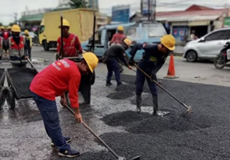 Kota Bekasi - Sejumlah petugas DBMSDA Kota Bekasi saat melakukan penutupan lubang jalan di Jalan I Gusti Ngurah Rai, sekitar wilayah Bekasi Barat.