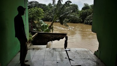 Warga mengamati rumahnya yang longsor akibat tergerus aliran Kali Bekasi di RT03/RW02 Teluk Pucung Bekasi Utara, beberapa waktu lalu. RAIZA SEPTIANTO/RADAR BEKASI.