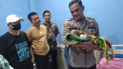 Kapolsek Setu, AKP Usep Aramsyah menggendong bayi yang ditelantarkan di Setu, Minggu (27/4/2025). Foto: Ist