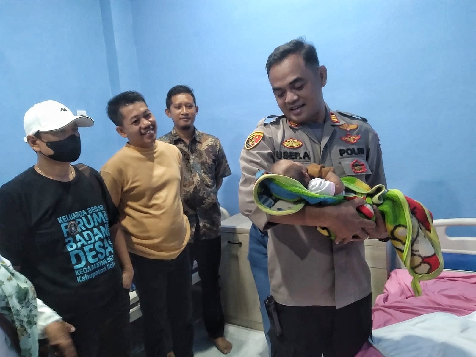 Kapolsek Setu, AKP Usep Aramsyah menggendong bayi yang ditelantarkan di Setu, Minggu (27/4/2025). Foto: Ist