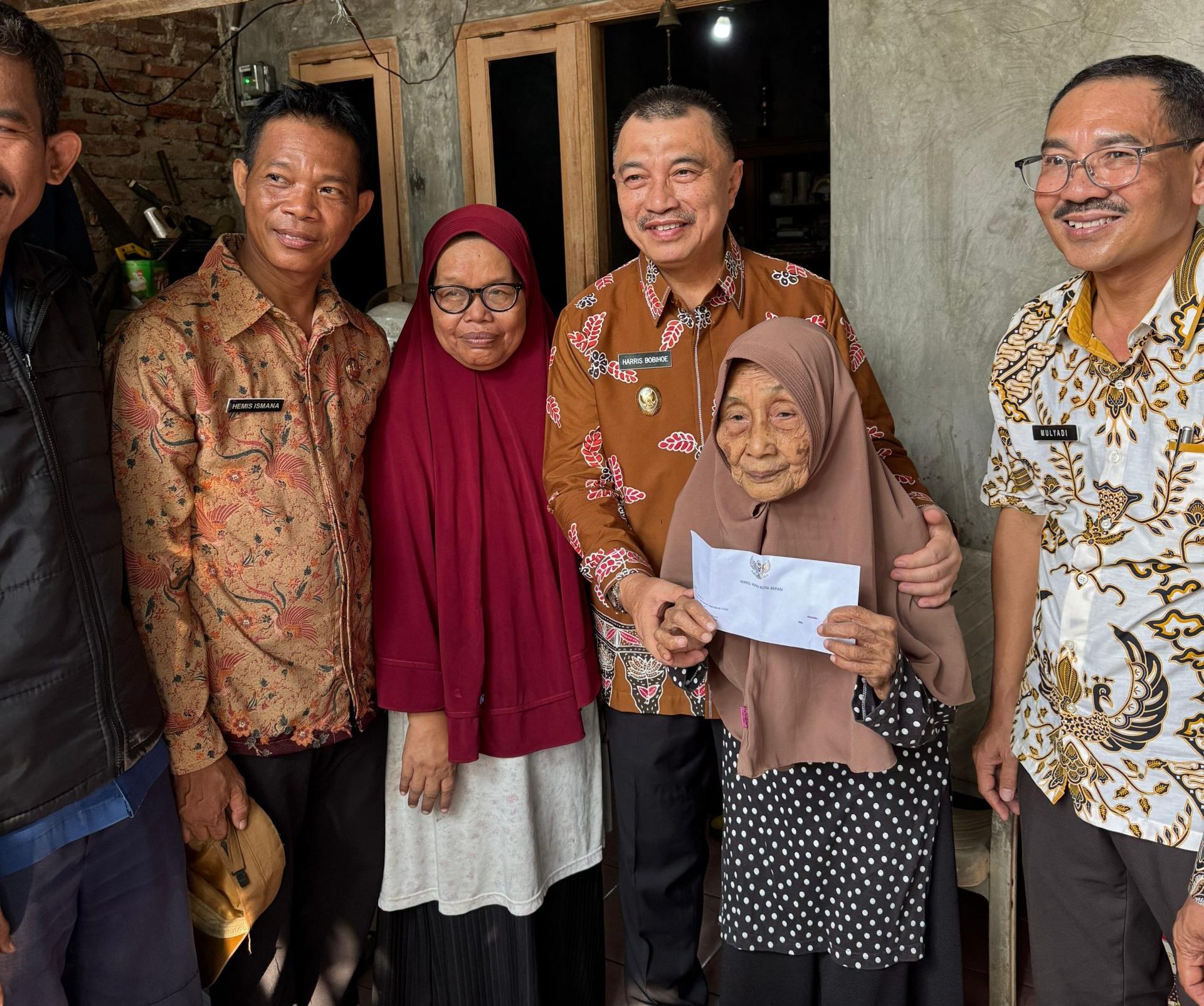 Senyum bahagia terpancar di wajah Suratinah, ibu asuh dari Wakil Wali Kota Bekasi Abdul Harris Bobihoe, saat menerima kunjungan kasih sayang dari orang nomor dua di Kota Bekasi tersebut.