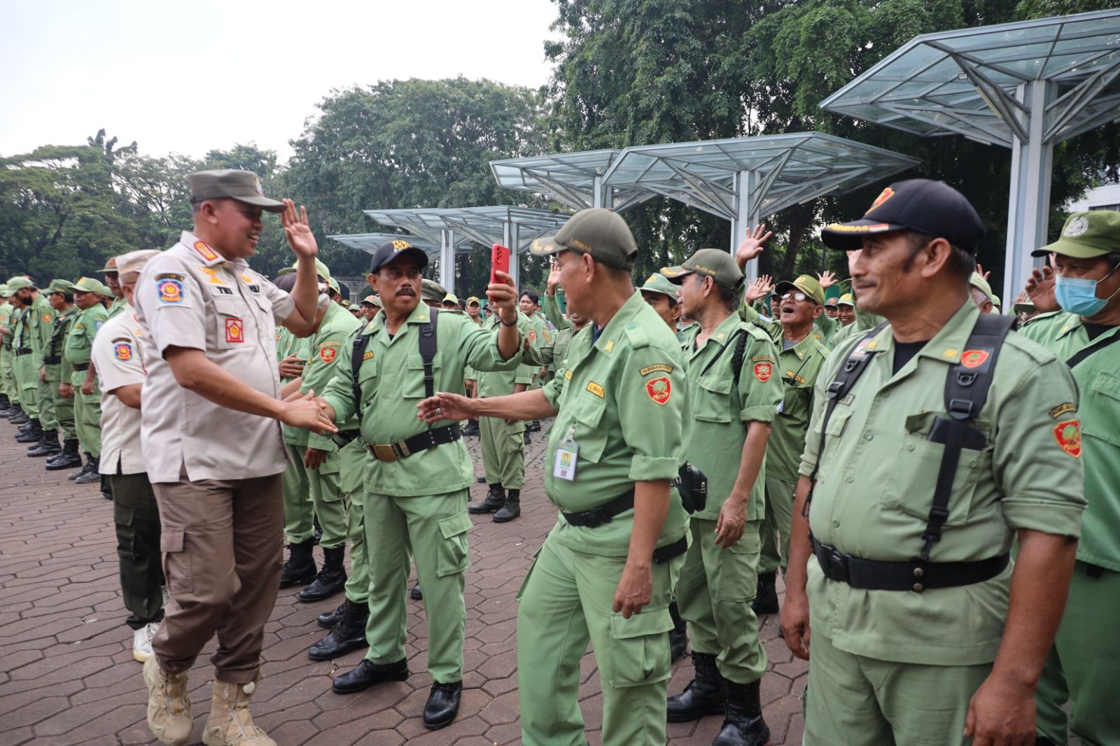 Kota Bekasi - Wali Kota Bekasi Tri Adhianto menyapa para linmas usai melaksanakan apel gabungan di Alun - Alun M. Hasibuan, Rabu (21/5/2025).