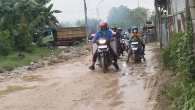 Kabupaten Bekasi - Pemotor melintas Jalan Raya Cikarang Bekasi Laut (CBL) – Sukajaya di Kecamatan Cibitung, Kabupaten Bekasi., yang berlumpur.