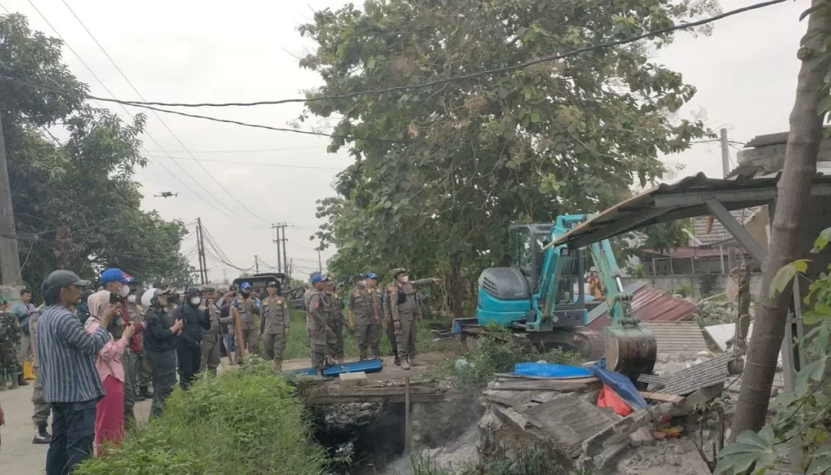 Kabupaten Bekasi - Pemerintah Kabupaten Bekasi menertibkan sebanyak 99 bangunan liar di sepanjang bantaran Saluran Sekunder (SS) Kampung Gabus Tengah, Desa Srimukti, Kecamatan Tambun Utara, Rabu (18/6/2025).