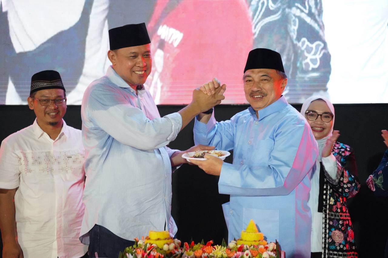 Kota Bekasi - Wali Kota Bekasi Tri Adhianto dan Wakil Wali Kota Bekasi Harris Bobihoe bersama Ketua DPRD Kota Bekasi Sardi Effendi saat memotong tumpeng bersyukur atas capaian 100 hari kerja Walikota dalam momen Nobar Timnas Indonesia vs China di Plaza Patriot Candrabahaga, Kamis (5/6/2025) malam.