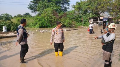 Kabupaten Bekasi - Genangan air setinggi 50 hingga 80 sentimeter di Jalan Raya Perjuangan, tepatnya di wilayah Kelurahan Kebalen, Kecamatan Babelan, Kabupaten Bekasi, pada Selasa pagi (8/7/2025).