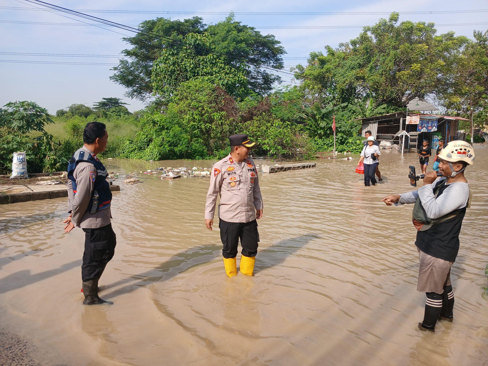 Kabupaten Bekasi - Genangan air setinggi 50 hingga 80 sentimeter di Jalan Raya Perjuangan, tepatnya di wilayah Kelurahan Kebalen, Kecamatan Babelan, Kabupaten Bekasi, pada Selasa pagi (8/7/2025).