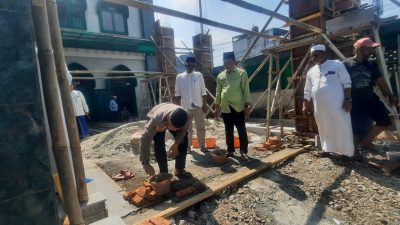 Kota Bekasi - Kapolsek Bekasi Barat AKP Wahyudi meletakkan batu pertama secara simbolis dimulainya perluasan bangunan Masjid Jami Al Falah di Kp Dua, Kranji, Bekasi Barat, Jumat (1/8/2025).