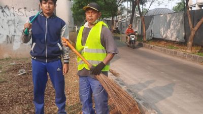 Kota Bekasi - Dahlan Sulaiman, warga RT 06 RW 02 Kelurahan Jakamulya, Bekasi Selatan, tetap memilih turun tangan menjaga kebersihan lingkungan bersama anaknya tanpa gaji. Foto: Septian/Gobekasi.id