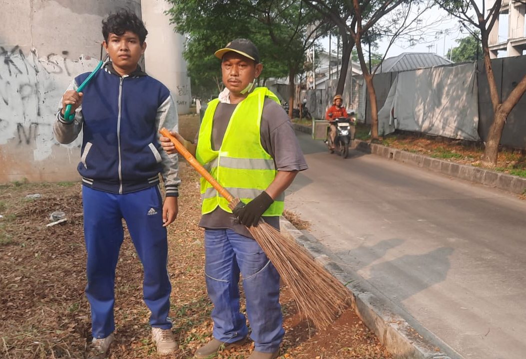 Kota Bekasi - Dahlan Sulaiman, warga RT 06 RW 02 Kelurahan Jakamulya, Bekasi Selatan, tetap memilih turun tangan menjaga kebersihan lingkungan bersama anaknya tanpa gaji. Foto: Septian/Gobekasi.id