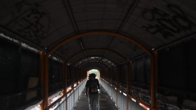 Kota Bekasi - Warga melintas di JPO Jalan Ahmad yani yang penuh vandalisme dan lantai keropos, Rabu (20/8/2025). Foto: Septian/Gobekasi.id