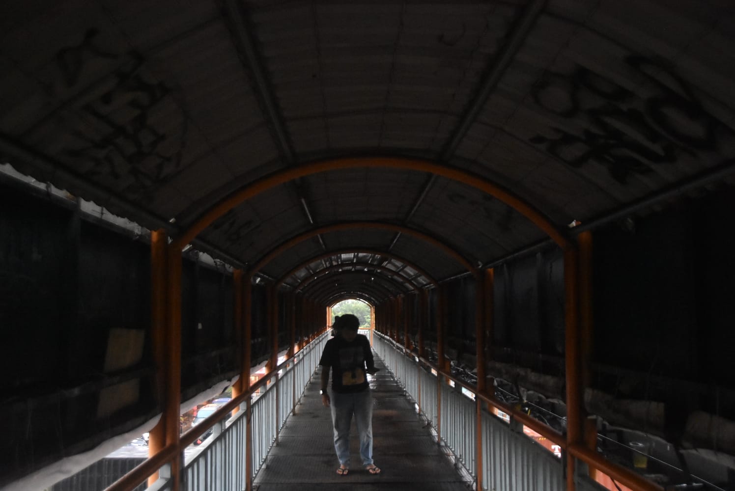 Kota Bekasi - Warga melintas di JPO Jalan Ahmad yani yang penuh vandalisme dan lantai keropos, Rabu (20/8/2025). Foto: Septian/Gobekasi.id