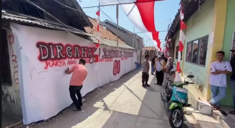 Kabupaten Bekasi - Warga di Kampung Rengasbandung Barat, Desa Karangsambung, Kecamatan Kedungwaringin, Kabupaten Bekasi, membentangkan Bendera Merah Putih sepanjang satu kilometer di atas jalan kampung mereka. Foto: Ist