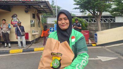 Kota Bekasi - Selly (30), seorang pengemudi ojek online wanita di Bekasi usai mendapat bingkisan Sembako dari Polres Metro Bekasi Kota, Senin (8/9/2025). Foto: Septian/Gobekasi.id.