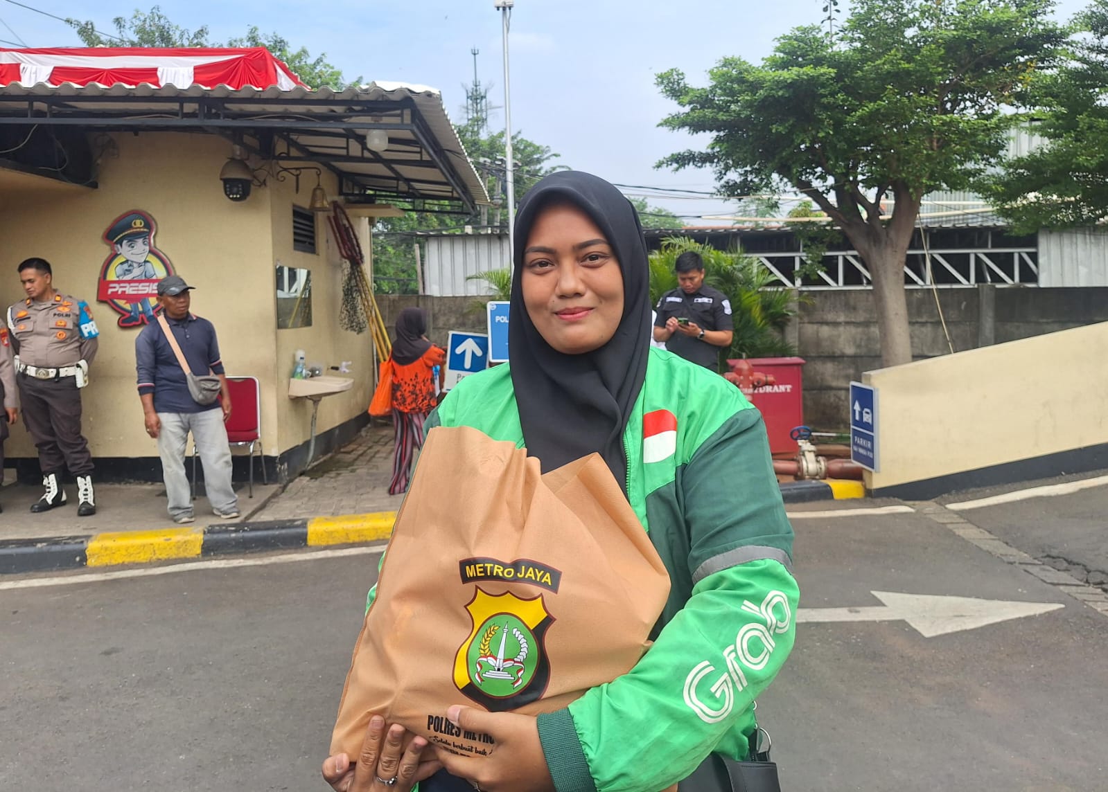 Kota Bekasi - Selly (30), seorang pengemudi ojek online wanita di Bekasi usai mendapat bingkisan Sembako dari Polres Metro Bekasi Kota, Senin (8/9/2025). Foto: Septian/Gobekasi.id.