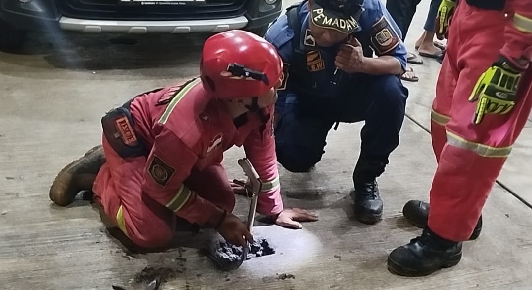 Kota Bekasi - Disdamkarmat Kota Bekasi membantu warga mengevakuasi Iphone 14 milik warga yang tercebur ke selokan beton di Pondok Gede, Selasa (16/9/2025). Foto: Ist