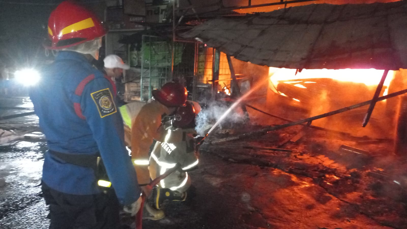 Kota Bekasi - Petugas Disdamkarmat Kota Bekasi berupaya memadamkan kebakaran yang melanda tiga ruko di Jalan Cikunir Raya, Bekasi Selatan. (Dok. Disdamkarmat)