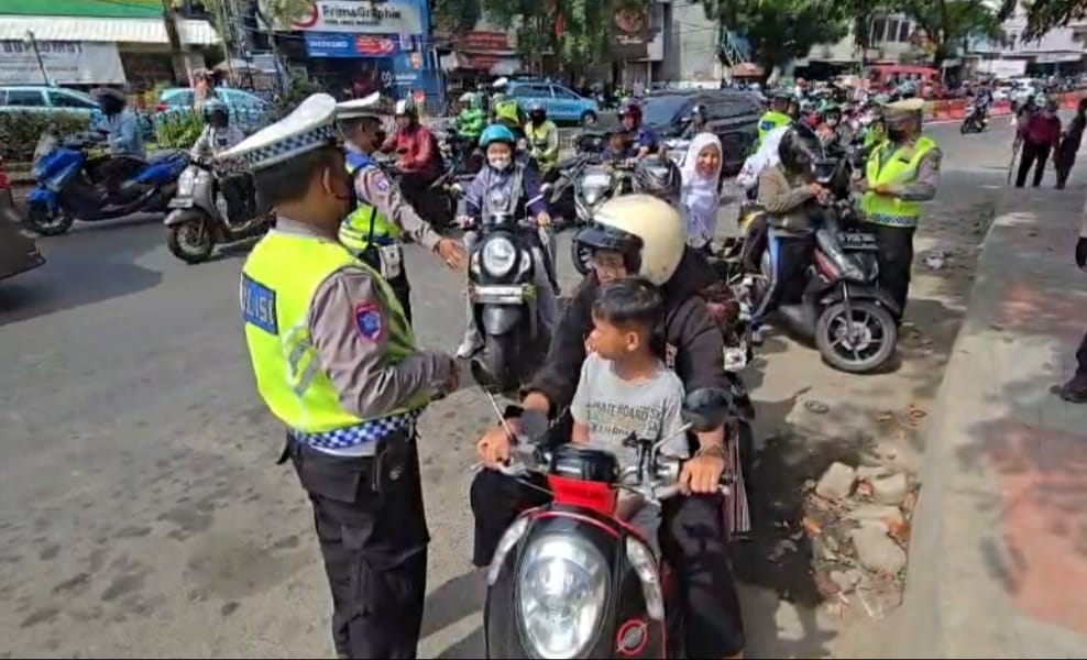 Kota Bekasi - Satlantas Polres Metro Bekasi Kota memberikan bunga kepada para pengedara yang tertib berlalu lintas, Jumat (28/11/2025). Foto: Ist/Gobekasi.id.