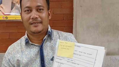 Kota Bekasi - Ketua Umum PPAMI, Garisah Indarul Haq memegang satu bundel dokumen dugaan korupsi Perumda Tirta Patriot sebelum diserahkan ke Pidsus Kejagung, Jumat (28/11/2025). Foto: Gobekasi.id.