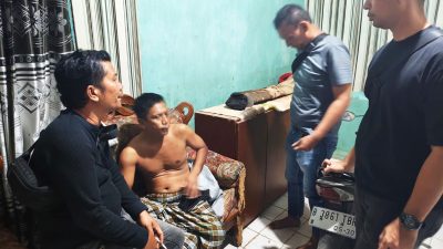 Kabupaten Bekasi - Surya, terduga pelaku penipuan dengan modus menjanjikan korban dapat masuk kerja dijemput paksa aparat Polsek Cikarang Pusat saat di rumahnya Dusun Krajan, Kecamatan Tirtajaya, Kabupaten Karawang, Selasa (2/12/2025). Foto: Ist