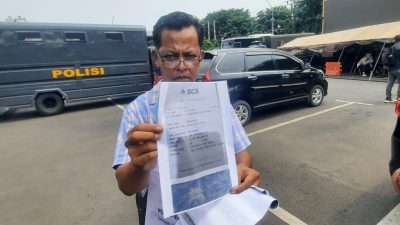 Kota Bekasi - Korban, Josman Sinaga (55), menunjukan bukti transfer yang sudah di print dalam kertas A4 di Polres Metro Bekasi Kota, Kamis (11/12025). Foto: Ist/Gobekasi.id.