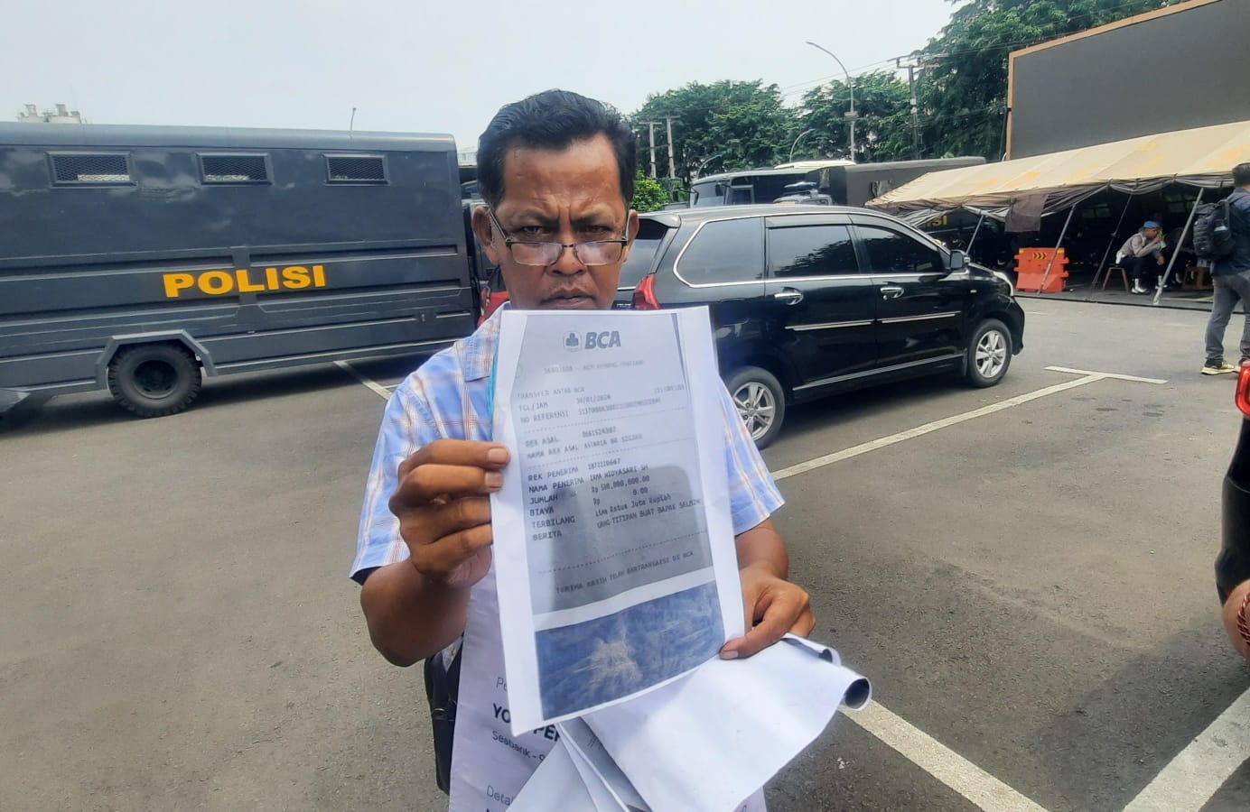 Kota Bekasi - Korban, Josman Sinaga (55), menunjukan bukti transfer yang sudah di print dalam kertas A4 di Polres Metro Bekasi Kota, Kamis (11/12025). Foto: Ist/Gobekasi.id.