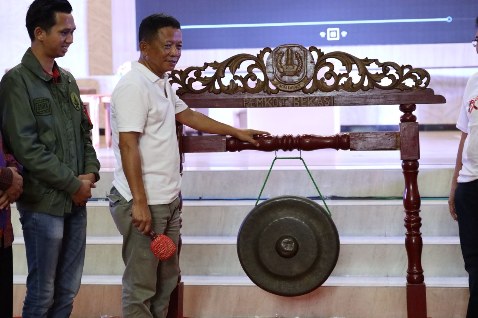 Kota Bekasi - Sekda Kota Bekasi, Junaedi memukul gong sebagai tanda pembukaan kegiatan Peringatan Hari AIDS Sedunia (HAS) 2025 yang digelar di Balai Patriot, Kota Bekasi, Minggu (15/12/2025). Foto: Ist/Gobekasi.id.