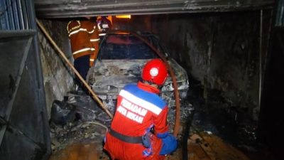 Kota Bekasi - Petugas Disdamakarmat Kota Bekasi saat melakukan proses pemadaman di rumah yang terbakar. 1 unit mobil hangus tinggal kerangka, Senin (29/12/2025) malam. Foto: Septian/Gobekasi.id.