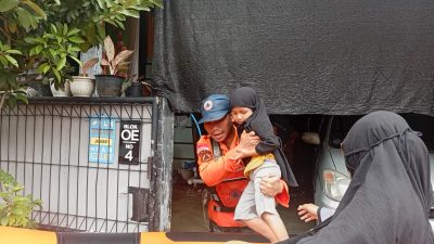 Kota Bekasi - Personel BPBD mengevakuasi seorang anak di Blok 0E Nomor 4, Kelurahan Pejuang, Medansatria, Kota Bekasi. Dokumentasi/BPBD