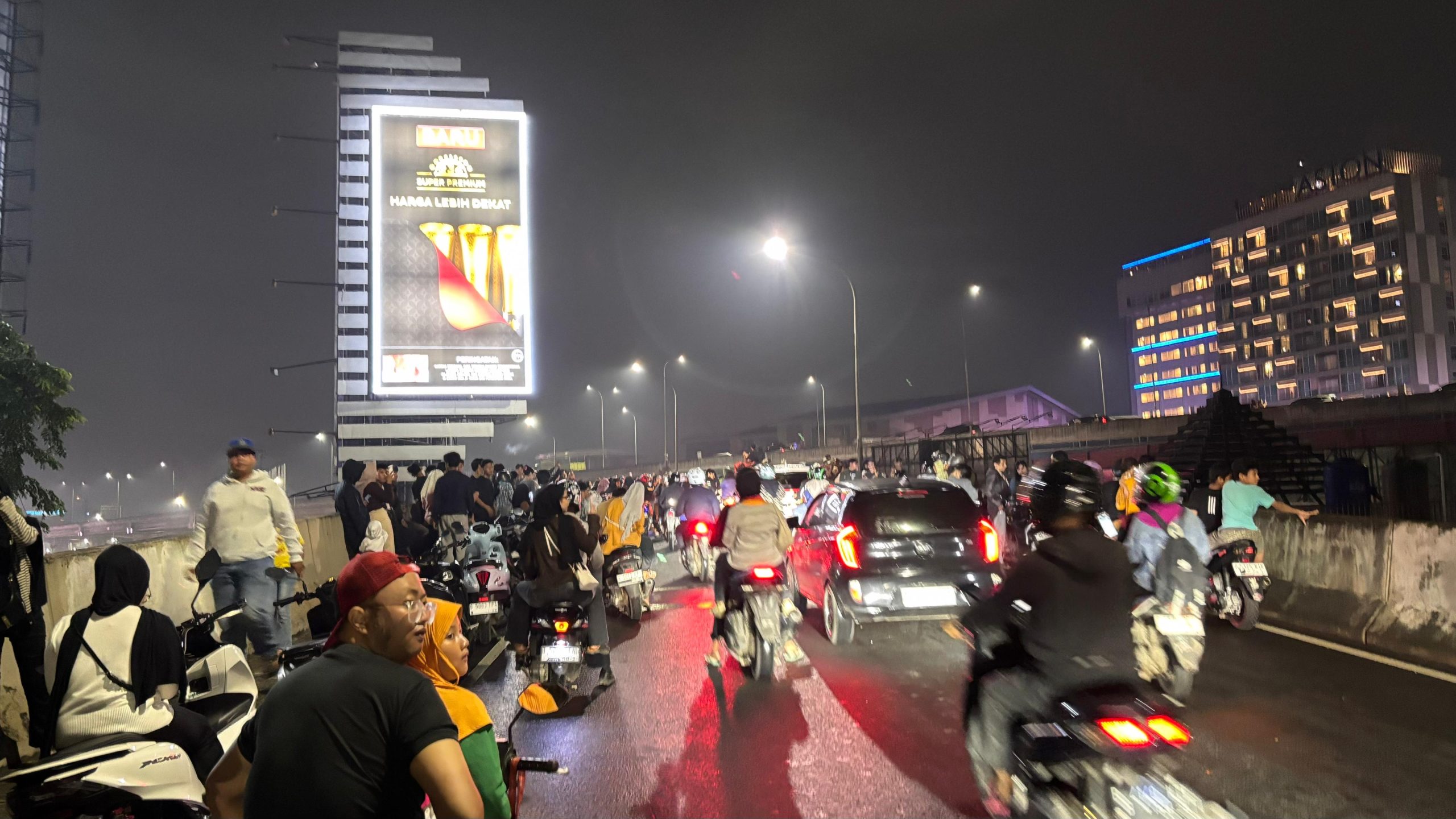 Kota Bekasi - Warga memadati kawasan Flyover Metropolitan Kota Bekasi pada malam pergantian tahun, Rabu (31/12/2025). Meski terdapat imbauan sterilisasi tanpa petasan, masyarakat tetap berkumpul untuk menyaksikan suasana pergantian Tahun Baru dari ketinggian. Sejumlah pengendara motor tampak berhenti di badan jalan dan ikut meramaikan suasana malam pergantian tahun. (Dok.Daffa Bhagas Alkautsar)